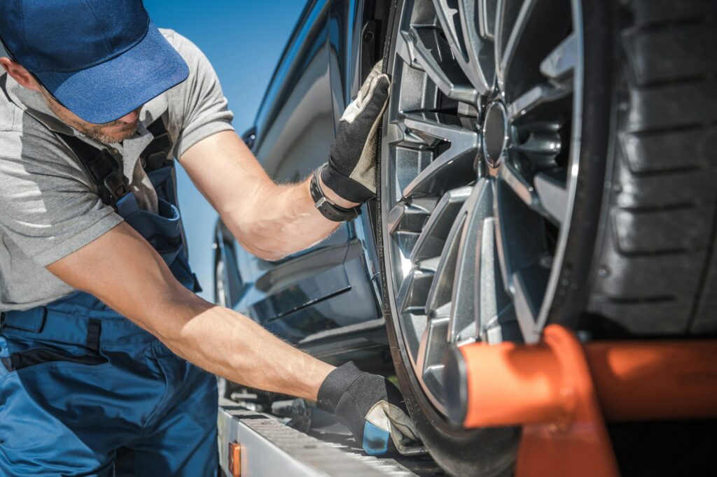 Towing Truck Worker Preparing For Car Shipment